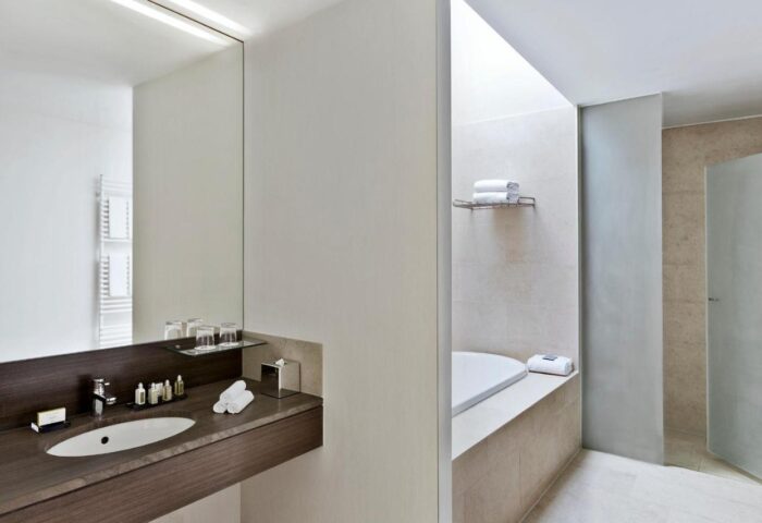 Vienna Marriott Hotel bathroom. Gay-friendly hotel with modern design, featuring a sink, mirror, bathtub, and shower. Great for gay travel.