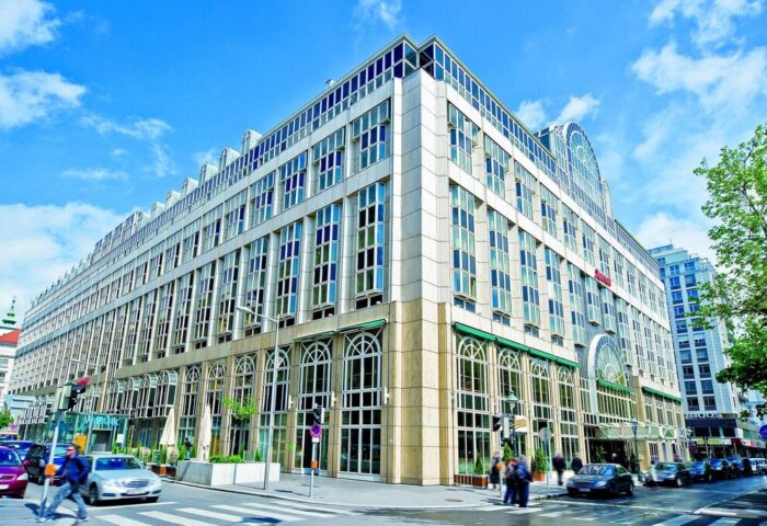 Facade of Vienna Marriott Hotel, a gay-friendly hotel in Vienna, Austria. Modern architecture, many windows, street view, sunny day.