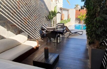Villa Adler Gay Men Only hotel patio with lounge seating, dining table, and pool view. Gay-friendly hotel for gay travelers.