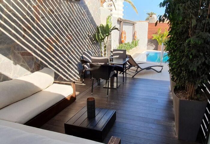 Villa Adler Gay Men Only hotel patio with lounge seating, dining table, and pool view. Gay-friendly hotel for gay travelers.