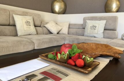 Villa Adler Gay Men Only hotel room detail. Fruit plate, keys, and a stylish sofa create a welcoming atmosphere. Gay-friendly hotel.