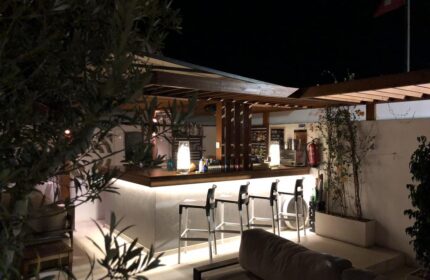 Villa Adler Gay Men Only hotel bar at night. Gay-friendly hotel with seating and drinks. Relaxing vacation spot.