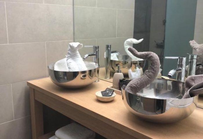 Villa Adler Gay Men Only hotel bathroom. Modern design with swan towel art. Gay-friendly hotel with luxury amenities for gay travelers.