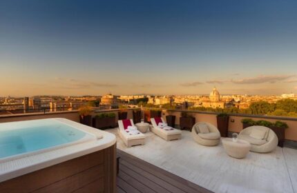 Villa Agrippina Gran Melia gay-friendly hotel rooftop terrace view. Rome skyline, jacuzzi, lounge chairs, and seating for a relaxing gay vacation.