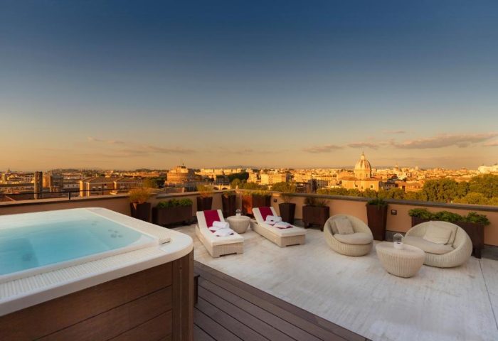 Villa Agrippina Gran Melia gay-friendly hotel rooftop terrace view. Rome skyline, jacuzzi, lounge chairs, and seating for a relaxing gay vacation.