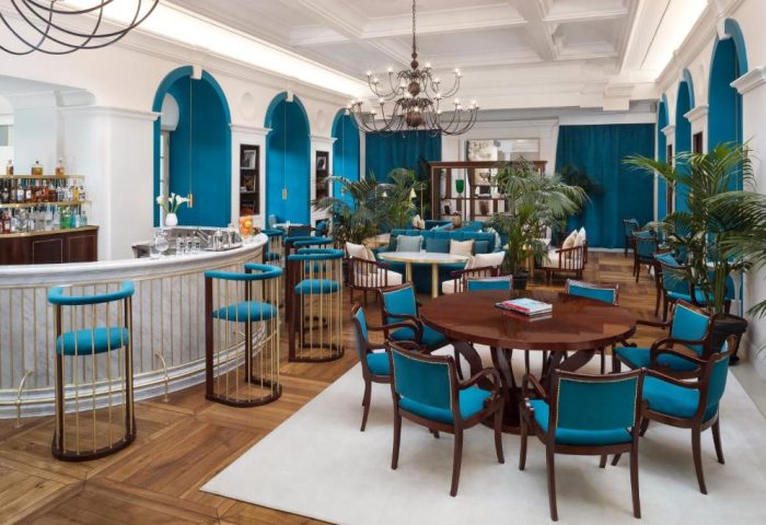 Villa Agrippina Gran Melia's stylish bar and lounge area. Gay-friendly hotel with blue accents, plants, and modern seating for a luxury experience.