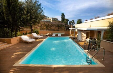 Villa Agrippina Gran Melia gay-friendly hotel pool view. Relaxing sun loungers by the pool. Ideal for gay travel in Rome, Italy.