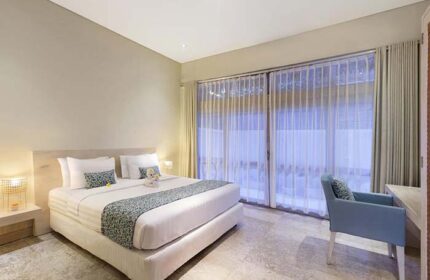 Villa Kresna Boutique and Suites gay-friendly hotel room. King bed, sheer curtains, desk, and chair. Luxury gay travel in Seminyak, Bali.