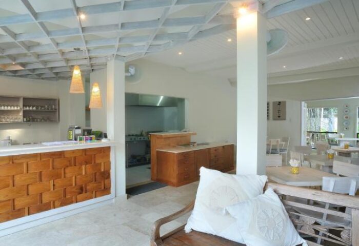 Villa Kresna Boutique and Suites interior. Gay-friendly hotel with kitchen, dining area, and wooden bench with pillows. Boutique hotel design.