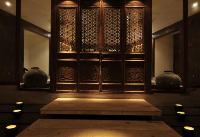 Villa Samadhi by Samadhi entrance. Gay-friendly hotel with carved wooden doors, stone steps, and ambient lighting. Luxury travel for gay men.