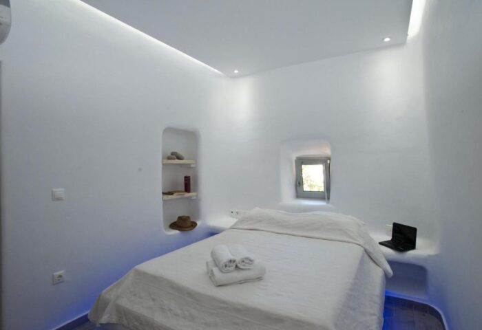 Villa Varnali Small Boutique gay-friendly hotel room. White walls, bed with towels, laptop, window, & shelves. Ideal for gay travel.
