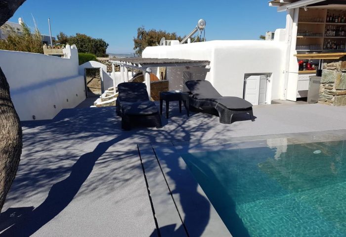 Villa Varnali Small Boutique gay-friendly hotel pool. Mykonos luxury travel for gay men's vacation. Sun loungers by the pool, outdoor bar.