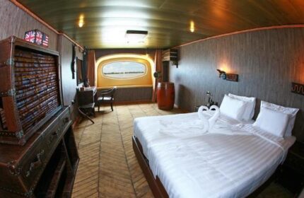 Vintage Luxury Yacht Hotel room. Gay-friendly hotel interior with a bed, swan towels, and nautical decor. Unique travel experience.