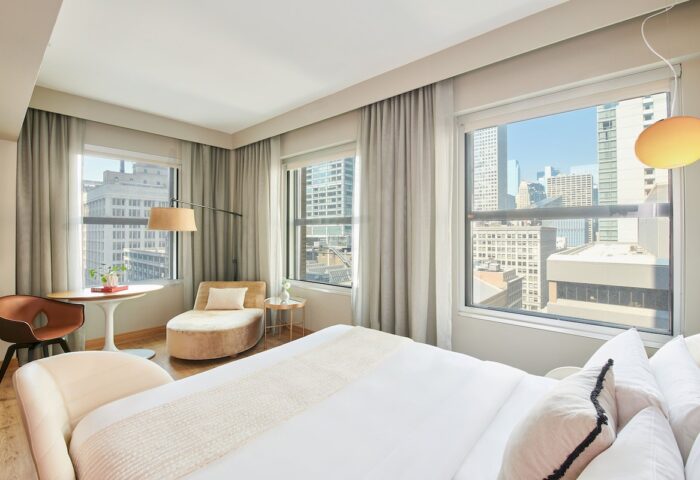 Virgin Hotels Chicago guest room. Gay-friendly hotel with city views, modern decor, chaise lounge, and comfortable bed. Perfect for gay travelers.