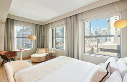 Virgin Hotels Chicago guest room. Gay-friendly hotel with city views, modern decor, chaise lounge, and comfortable bed. Perfect for gay travelers.