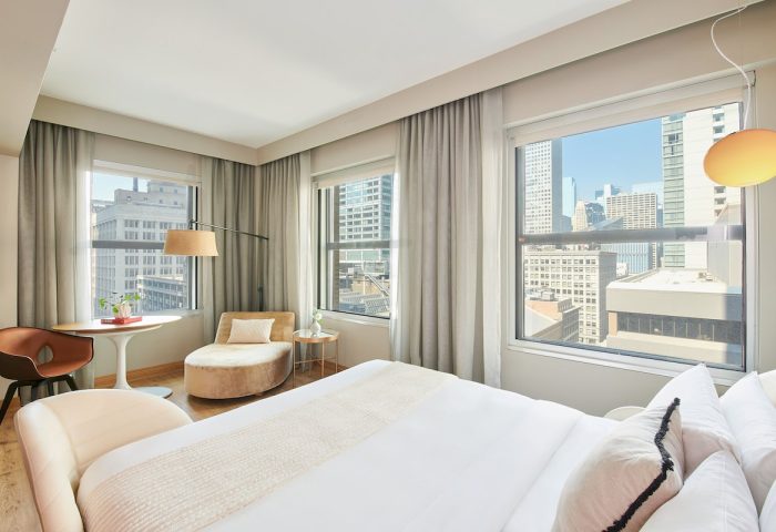 Virgin Hotels Chicago guest room. Gay-friendly hotel with city views, modern decor, chaise lounge, and comfortable bed. Perfect for gay travelers.