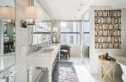 Virgin Hotels Chicago bathroom. Gay-friendly hotel with white tile, double vanity, and a bookshelf-style accent wall. Luxury travel.