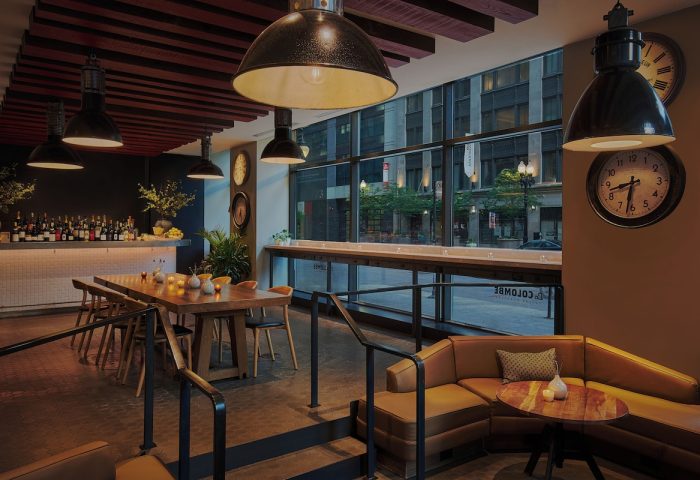 Gay-Friendly Virgin Hotels Chicago interior. Bar, dining table, and lounge area. Modern design, urban view. Great for gay travel in Chicago.