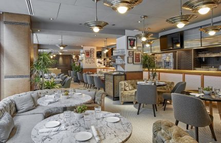 Virgin Hotels Chicago restaurant. Gay-friendly hotel with round marble tables, cushioned seating, and stylish lighting. Great for gay men travel.