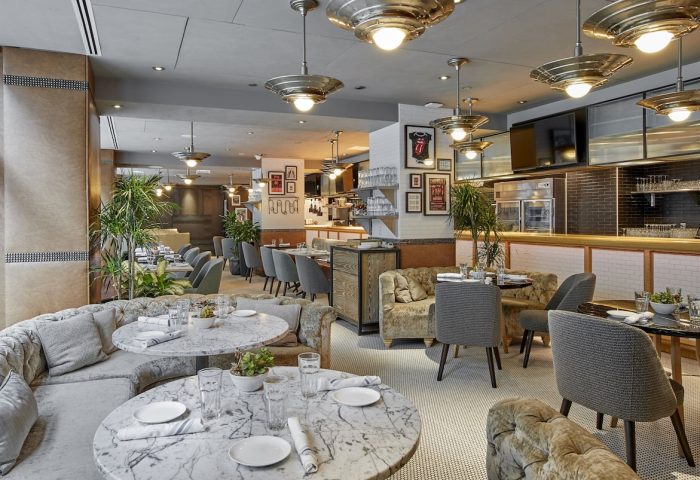 Virgin Hotels Chicago restaurant. Gay-friendly hotel with round marble tables, cushioned seating, and stylish lighting. Great for gay men travel.