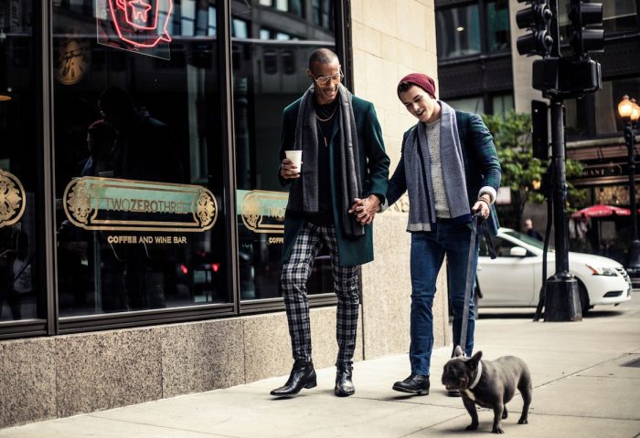 Gay couple holds hands outside Virgin Hotels Chicago with their dog. Gay-Friendly hotel for gay men travel advice in Chicago.