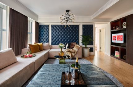 Virgin Hotels Chicago suite. Gay-friendly hotel living room with couch, champagne, and chic decor. Luxury travel for gay men.