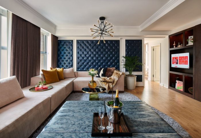 Virgin Hotels Chicago suite. Gay-friendly hotel living room with couch, champagne, and chic decor. Luxury travel for gay men.