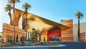 Virgin Hotels Las Vegas, a gay-friendly Curio Collection by Hilton. Exterior view of the hotel entrance with desert landscaping.