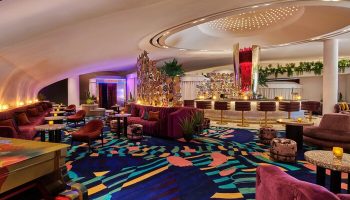 Virgin Hotels Las Vegas, a Curio Collection by Hilton, gay-friendly hotel. Stylish bar area with piano, seating, and colorful decor.
