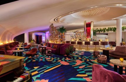 Virgin Hotels Las Vegas, a Curio Collection by Hilton, gay-friendly hotel. Stylish bar area with piano, seating, and colorful decor.
