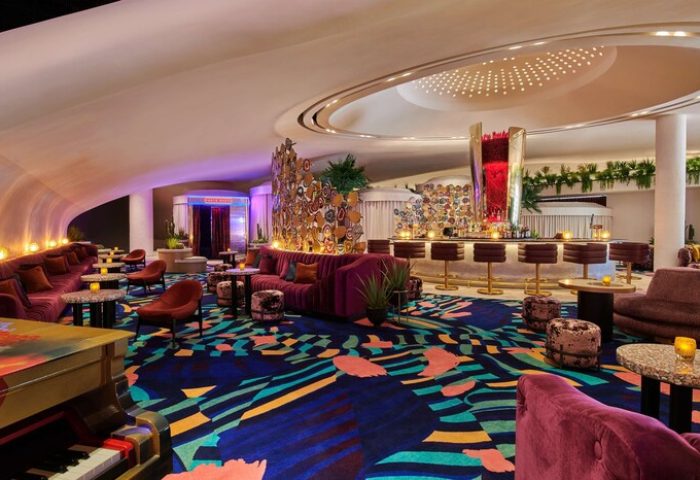 Virgin Hotels Las Vegas, a Curio Collection by Hilton, gay-friendly hotel. Stylish bar area with piano, seating, and colorful decor.