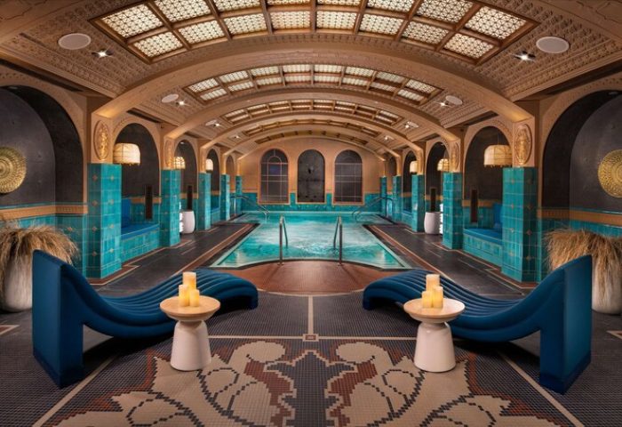 Indoor pool area at Virgin Hotels Las Vegas, Curio Collection by Hilton. Gay-friendly hotel with lounge chairs and decorative tile.