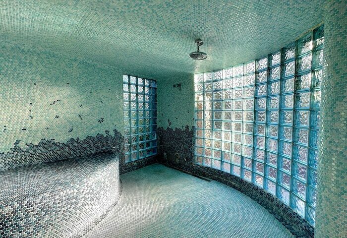 Vista Grande Resort's stylish bathroom with blue mosaic tiles, glass block wall, and shower. A gay men's resort offering luxury travel.