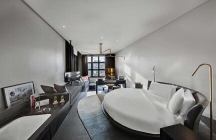 W Amsterdam gay-friendly hotel room. Round bed, desk, TV, and bathtub. Modern design, perfect for gay travelers. Luxury Amsterdam hotel.
