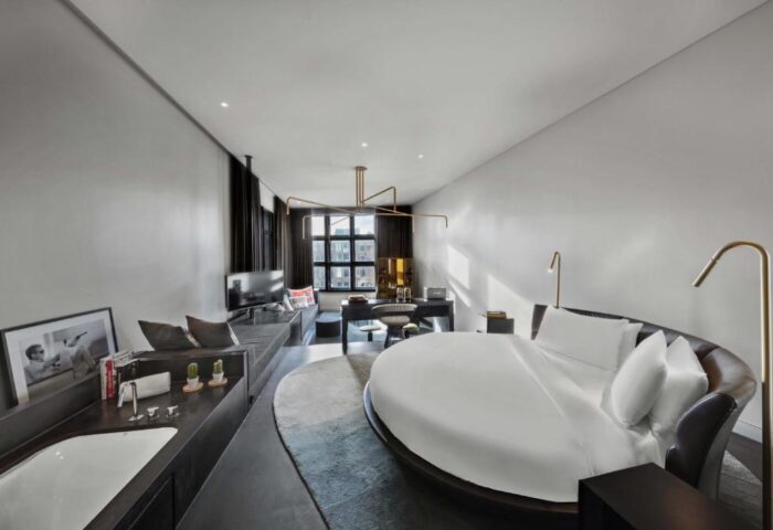 W Amsterdam gay-friendly hotel room. Round bed, desk, TV, and bathtub. Modern design, perfect for gay travelers. Luxury Amsterdam hotel.