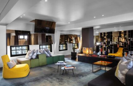 W Amsterdam gay-friendly hotel room with fireplace, modern furniture, and bookshelves. A stylish and welcoming space for gay travelers.