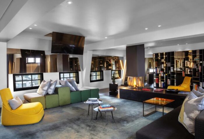 W Amsterdam gay-friendly hotel room with fireplace, modern furniture, and bookshelves. A stylish and welcoming space for gay travelers.