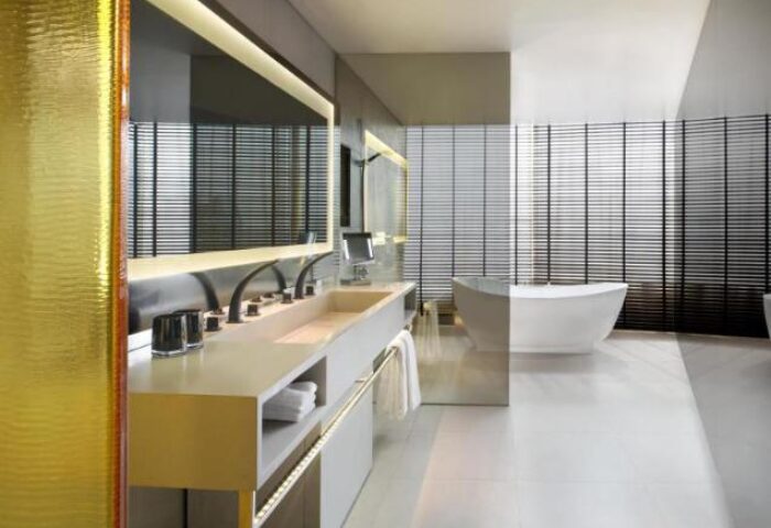 W Bangkok gay-friendly hotel pet-friendly modern bathroom. Bathtub, sink, and black blinds. Luxury design for gay travel in Thailand.