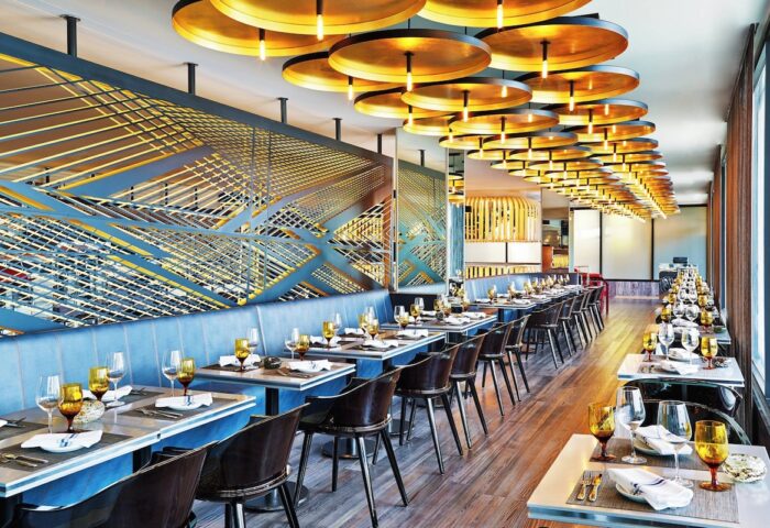 W Chicago Lakeshore gay-friendly hotel restaurant. Tables set, modern design, and unique lighting create an upscale dining experience.