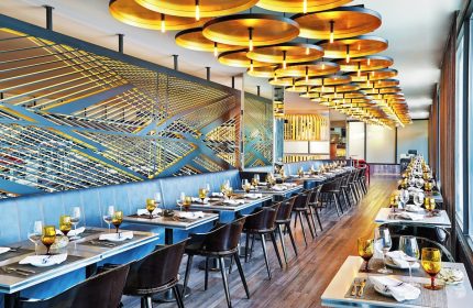 W Chicago Lakeshore gay-friendly hotel restaurant. Tables set, modern design, and unique lighting create an upscale dining experience.
