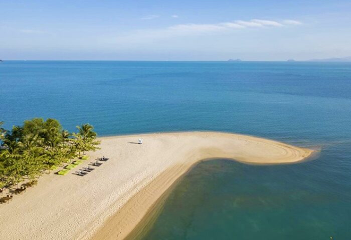 W Koh Samui's beach view. This gay-friendly hotel offers pet-friendly accommodations. Beach chairs and palm trees line the sandy shore.
