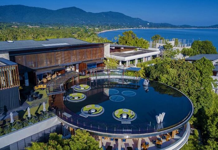 W Koh Samui aerial view. Gay-friendly, pet-friendly hotel with a unique round pool and lounge areas overlooking the ocean and lush landscape.