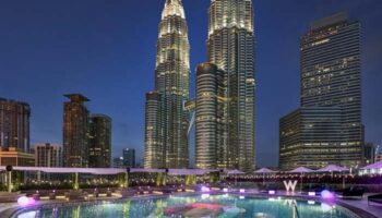 W Kuala Lumpur gay-friendly hotel pool at night. Petronas Towers backdrop. Luxury travel for gay men in Malaysia.