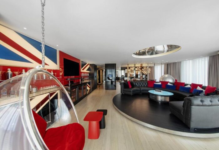 W London Leicester Square hotel suite. Gay-friendly, pet-friendly design with Union Jack decor, hanging chair, circular sofa, and bar.