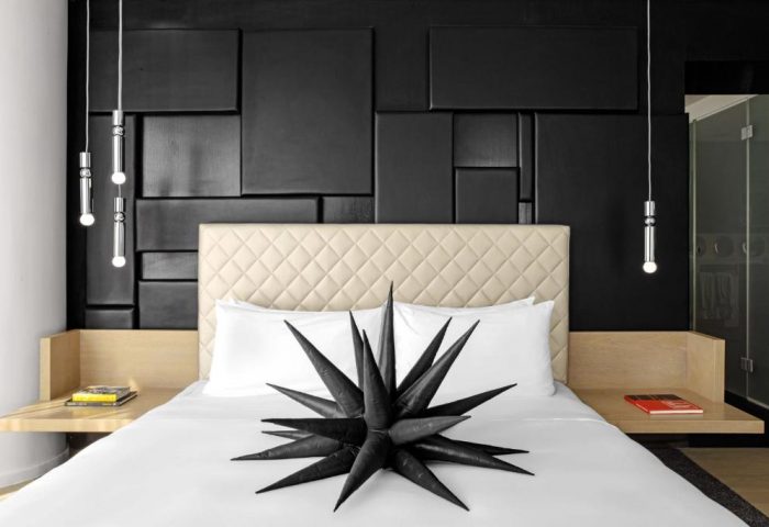 W London Leicester Square gay-friendly hotel bedroom. Modern design with black wall, star decoration, and stylish lighting. Pet-friendly option.