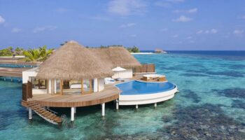 Gay-friendly W Maldives hotel overwater bungalow. Thatched roof villa with private pool. Luxury travel for gay men in the Maldives.