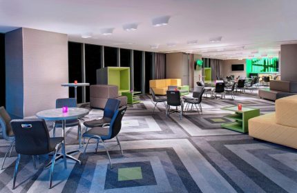 W Mexico City's gay-friendly hotel lounge area. Colorful, modern design with tables, chairs, and seating. A great place for gay travelers.