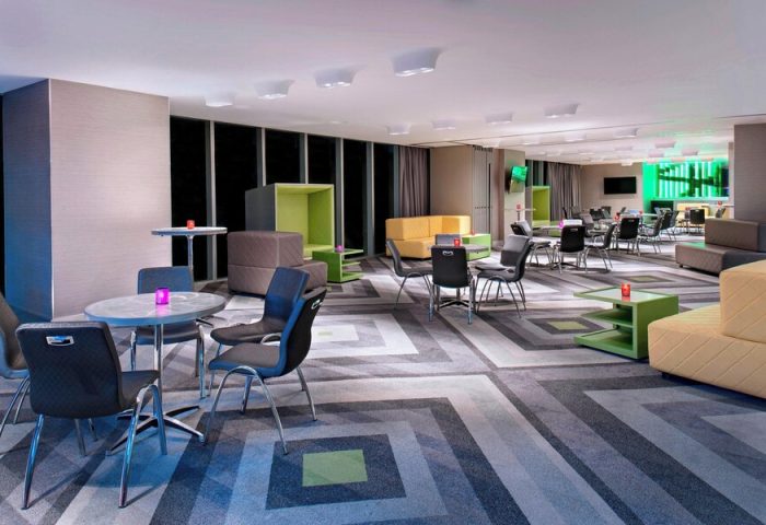 W Mexico City's gay-friendly hotel lounge area. Colorful, modern design with tables, chairs, and seating. A great place for gay travelers.