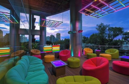 W Mexico City gay-friendly hotel rooftop lounge. Colorful seating, neon lights, and city views. A vibrant space for LGBTQ+ travelers.