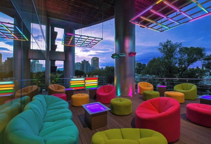 W Mexico City gay-friendly hotel rooftop lounge. Colorful seating, neon lights, and city views. A vibrant space for LGBTQ+ travelers.